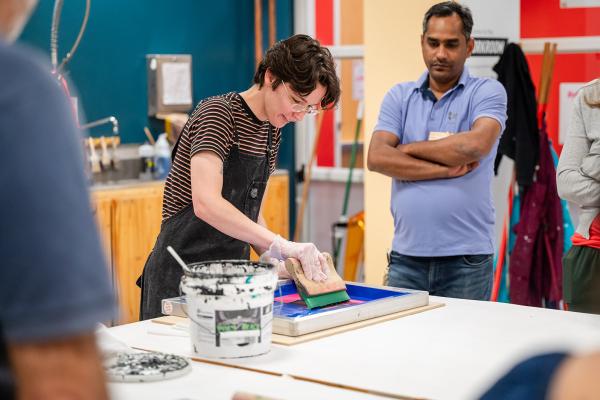 An Olin staff member partakes in the Makerspace Institute screen printing event. 