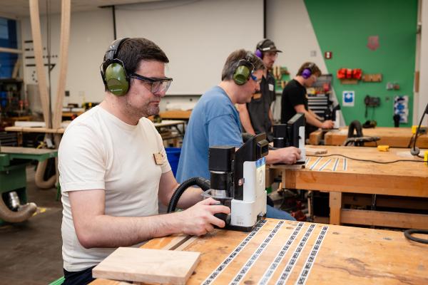 Makerspace Institute participants using machinery in one of the Shops.